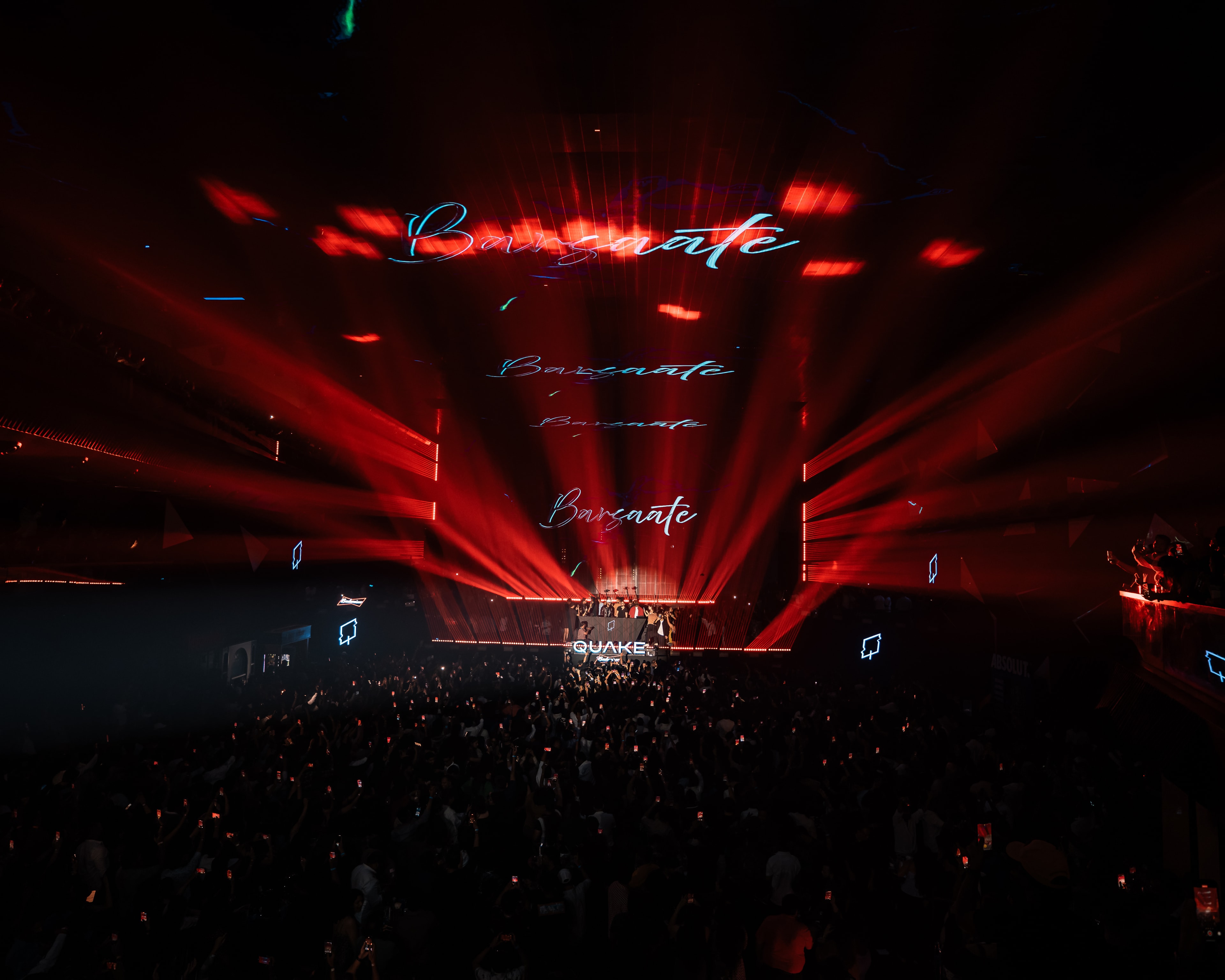 Red lasers over a packed floor at Quake, Barsaate on the screens